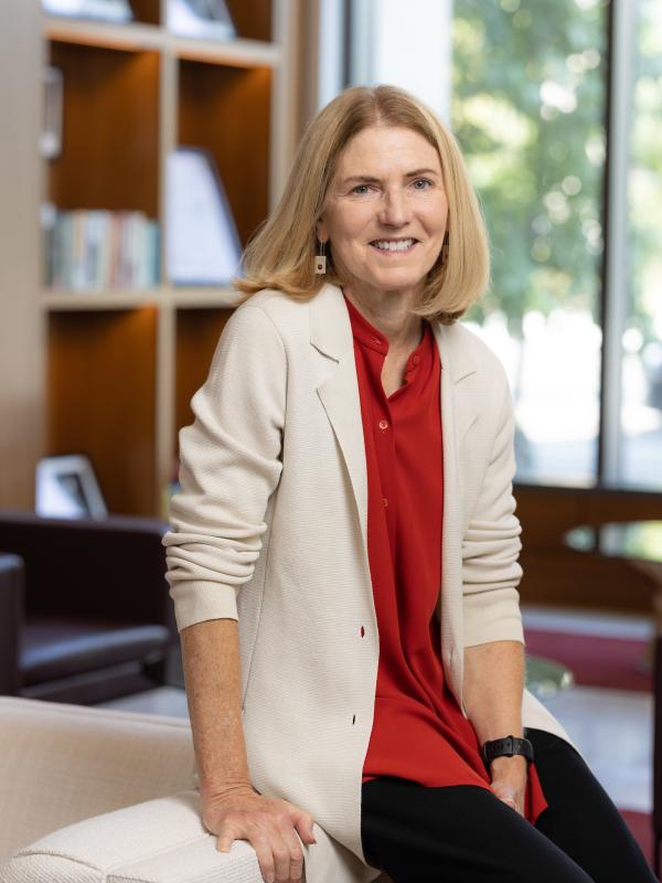 Professor Lisa Florman seated on the edge of a couch in her office